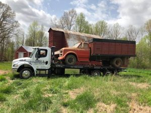 truck towing farm equipment that is not working